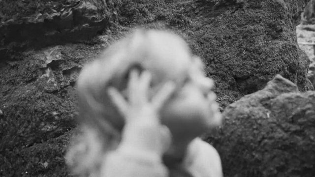 Video Reference: black and white, blurred, close-up, person, hand on face, outdoor, rocks, nature, portrait, abstract, motion blur, monochrome
