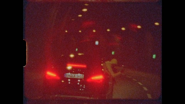 Video Reference: night, road, car, taillights, traffic, license plate, street lights, blur, dark, vehicle, pedestrian, urban, low light