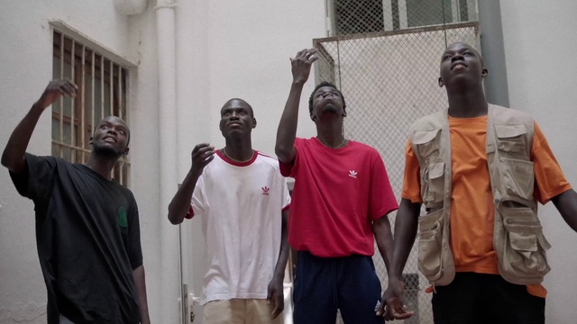 Video Reference: Sleeve, Temple, Window, Shorts, T-shirt, Event, Microphone, Team, Town, Room