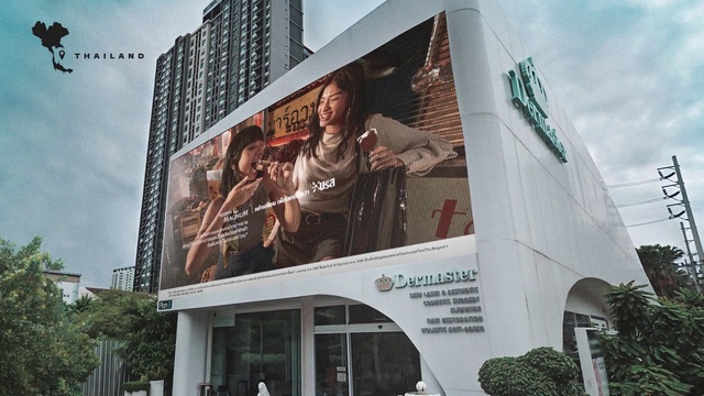 Video Reference: Sky, Daytime, Cloud, Building, Billboard, Facade, City, Font, Metropolitan area, Urban area