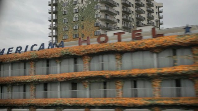 Video Reference: hotel, building, architecture, urban, facade, balconies, flowers, ivy, high-rise, city, exterior, blurred, motion