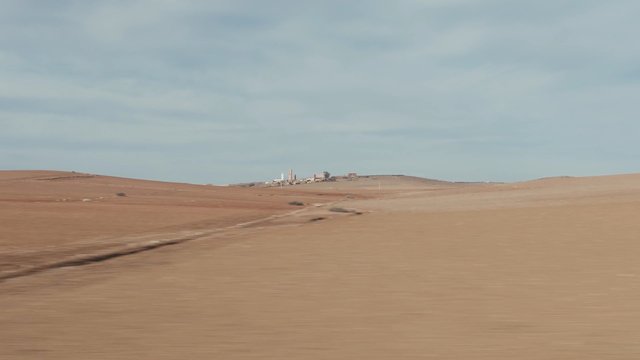 Video Reference: landscape, desert, rural, fields, horizon, sky, open land, arid, countryside, travel, outdoors, panoramic
