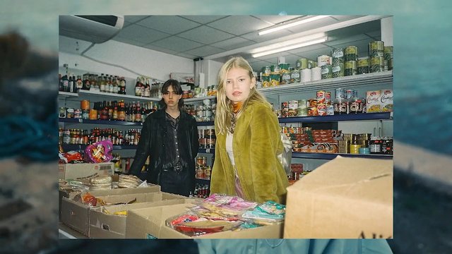 Video Reference: grocery store, convenience store, indoor, two people, shelves, canned goods, bottles, counter, retail, shop, portrait, flash photography