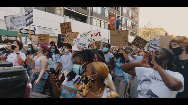 Video Reference: Hat, People, Crowd, Event, Fun, Sun hat, Luggage and bags, T-shirt, Handwriting, Rebellion