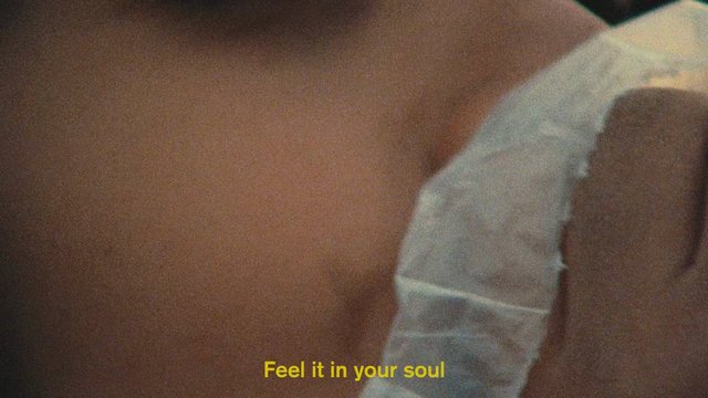 Video Reference: close-up, blurred, indistinct, fabric, texture, subtitle, text, yellow text, abstract, macro, out of focus