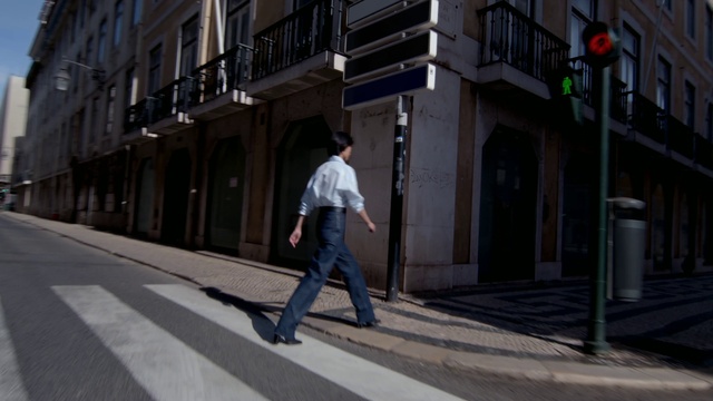 Video Reference: Window, Road surface, Building, Asphalt, Sidewalk, Neighbourhood, City, Urban design, Traffic light, Road
