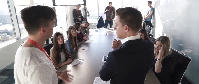 Video Reference: Hair, Hand, Outerwear, Shirt, Table, Product, Coat, Gesture, Chair, Interaction