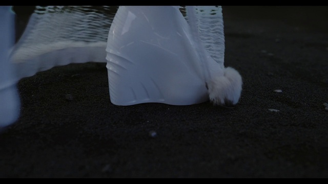 Video Reference: Glove, Dress, Feather, Human leg, Bridal accessory, Asphalt, Plastic bag, Wing, Electric blue, Transparent material