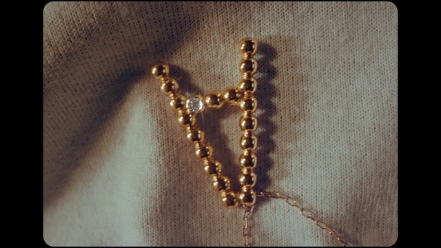 Video Reference: Body jewelry, Gesture, Gold, Necklace, Religious item, Jewellery, Natural material, Jewelry making, Metal, Rectangle