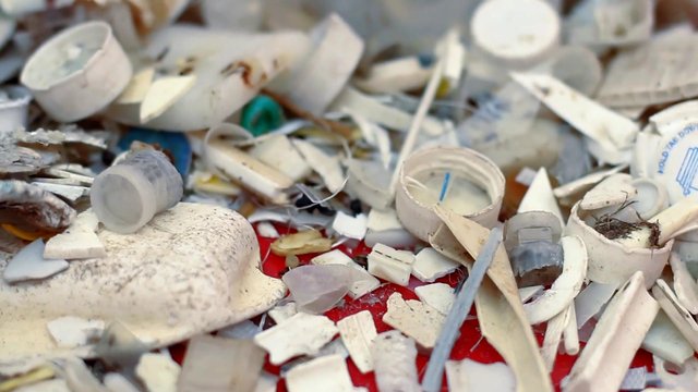 Video Reference: plastic, debris, waste, trash, recycling, litter, broken, fragment, close-up, pollution, scrap, mess, discarded, surface, industrial, environment
