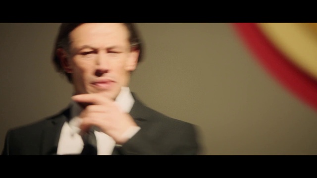 Video Reference: Forehead, Nose, Cheek, Eyebrow, Mouth, Flash photography, Jaw, Gesture, Blazer, Formal wear