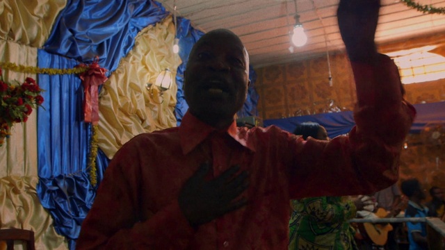 Video Reference: World, Temple, Gesture, Wood, Art, Event, T-shirt, Thumb, Visual arts, Wrinkle