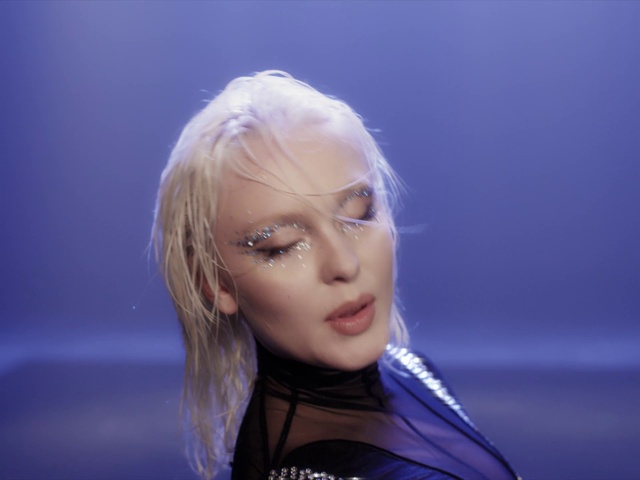 Video Reference: Lip, Chin, Eyebrow, Eyelash, Flash photography, Gesture, Music artist, Makeover, Sky, Performing arts