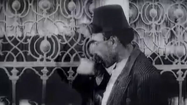 Video Reference: Outerwear, Fashion, Coat, Black-and-white, Gesture, Flash photography, Style, Suit, Font, Monochrome