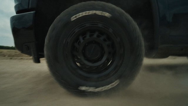 Video Reference: wheel, tire, vehicle, truck, spinning, motion blur, dirt road, close-up, transportation, outdoor, off-road, moving, dust