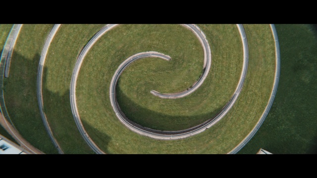 Video Reference: Automotive tire, Race track, Asphalt, Road surface, Automotive design, Font, Grass, Circle, Landscape, Flooring
