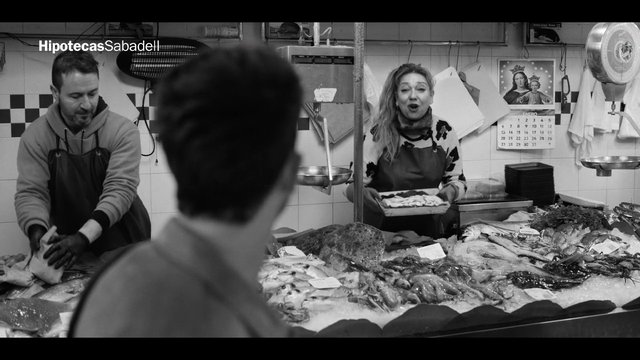 Video Reference: fish market, seafood, vendors, customer, indoor market, black and white, counter, fresh fish, food stall, shopping, local market, apron, workplace, commercial, people