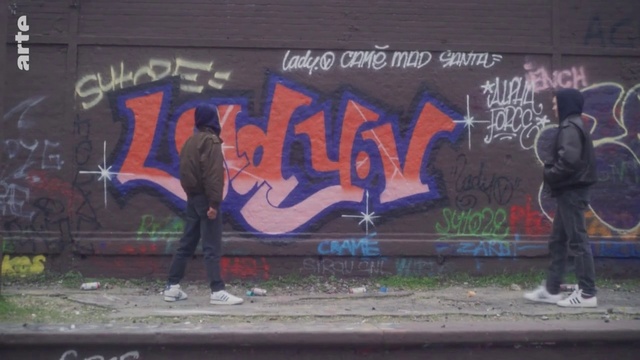 Video Reference: Handwriting, Graffiti, Art, Wall, Font, Tints and shades, Road, Asphalt, Electric blue, Mural