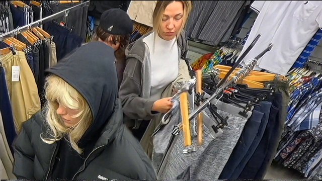 Video Reference: clothing store, shopping, women, racks, apparel, retail, indoor, casual wear, jackets, shirts, pants, browsing, store aisle, fashion, hangers