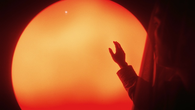 Video Reference: Atmosphere, Amber, Orange, Gesture, Sky, Heat, Atmospheric phenomenon, Tints and shades, Astronomical object, Backlighting