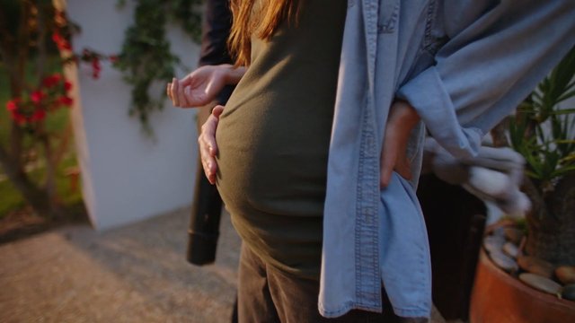 Video Reference: pregnancy, pregnant belly, close-up, outdoors, hands, expecting, family, warm light, garden, lifestyle, motherhood, person