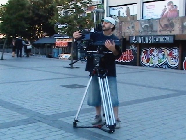 Video Reference: man, camera, tripod, videographer, urban, plaza, outdoor, graffiti, street, filming, equipment, cameraman