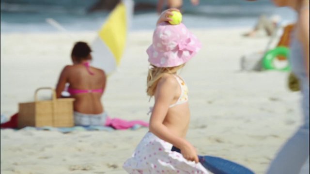 Video Reference: beach, child, sunhat, ball, sand, summer, outdoors, vacation, play, bikini, towel, seaside, family, blurred, daylight
