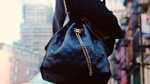 Video Reference: handbag, purse, black bag, quilted, gold chain, fashion, accessory, close-up, urban, street, outdoors, leather, luxury, woman