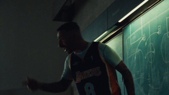 Video Reference: person, basketball jersey, Lakers, chalkboard, classroom, dark, blurred, silhouette, sports, indoors, presentation, diagram