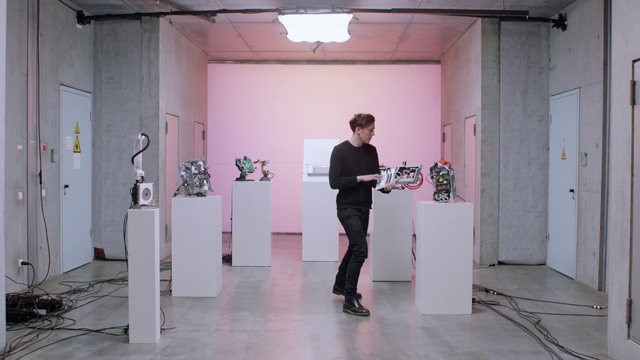 Video Reference: Standing, Art, Interior design, Automotive design, Sculpture, Flooring, Event, Houseplant, Magenta, Exhibition