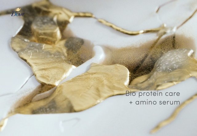 Video Reference: abstract, gold, white background, close-up, liquid, foil, cosmetic ad, product shot, branding, texture, luxury, serum, text overlay