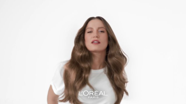 Video Reference: woman, long hair, wavy hair, portrait, white background, beauty, hair care, advertisement, studio, model, fashion, close-up, minimalist, cosmetics, brand logo