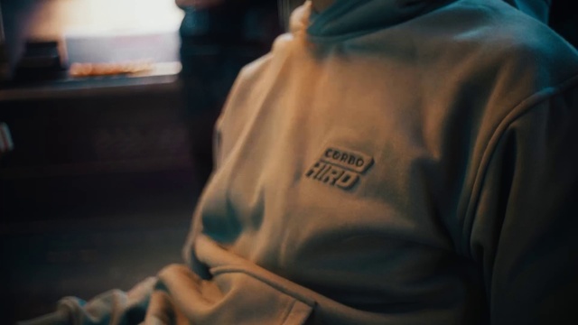 Video Reference: Sleeve, T-shirt, Elbow, Room, Human leg, Uniform, Sportswear, Sitting, Font, Fur