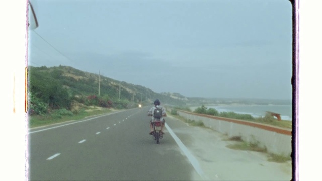 Video Reference: Sky, Vehicle, Motorcycle, Road surface, Motor vehicle, Asphalt, Mode of transport, Tire, Flag, Thoroughfare