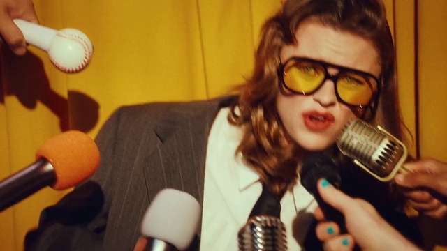 Video Reference: Microphone, Glasses, Lip, Hairstyle, Mouth, Goggles, Organ, Vision care, Audio equipment, Yellow