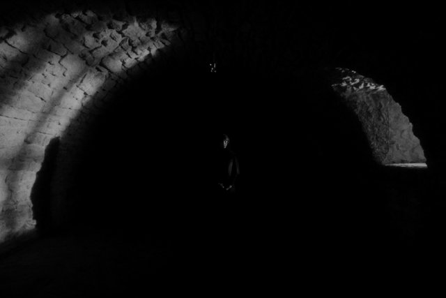 Video Reference: cave, tunnel, dark, black and white, rock, person, silhouette, underground, arch, shadow, low light, mysterious