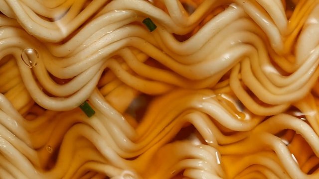 Video Reference: noodles, pasta, creamy sauce, close-up, food texture, abstract background, orange sauce, garnish, cooked pasta, macro, meal, comfort food