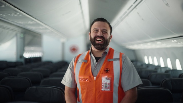 Video Reference: Smile, Beard, Sleeve, Collar, Aircraft cabin, Travel, Air travel, T-shirt, Engineering, Airline