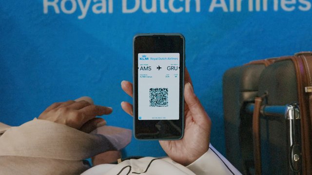 Video Reference: airport, boarding pass, smartphone, QR code, airline, travel, passenger, luggage, ticket, KLM, flight, seated, transit, mobile screen