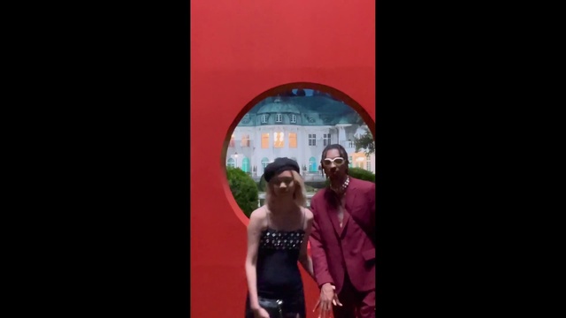 Video Reference: Flash photography, Gesture, Dress, Sunglasses, Entertainment, Magenta, Formal wear, Event, Fun, Suit