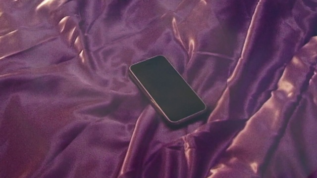 Video Reference: Purple, Sleeve, Textile, Gesture, Grey, Violet, Collar, Gadget, Material property, Communication Device