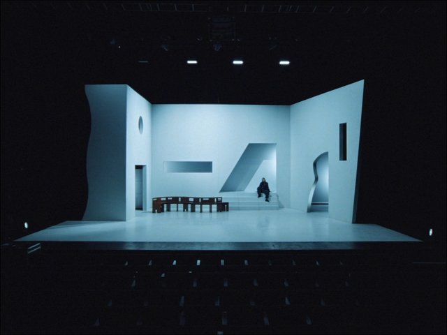 Video Reference: minimalist, stage, set design, geometric, white interior, theater, modern, abstract, architecture, seated person, indoor, lighting, performance, empty space