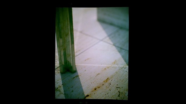 Video Reference: close-up, floor, tile, shadow, metal, glass, vertical, interior, abstract, texture, geometric, light, green, surface, corner, minimal