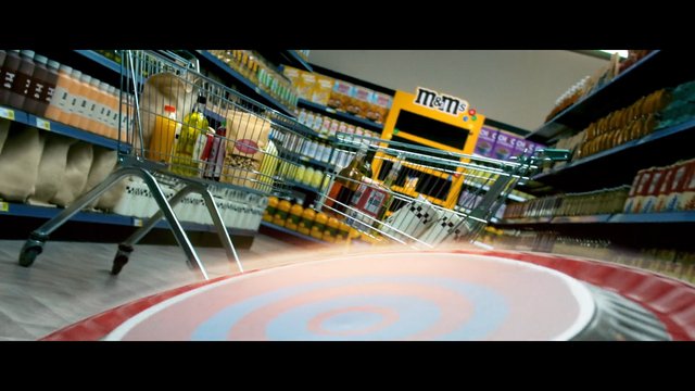Video Reference: grocery store, shopping cart, aisle, supermarket, shelves, products, retail, food, snacks, beverages, M&M's display, low angle, indoor, consumer goods