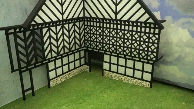 Video Reference: model, miniature, house, half-timbered, lattice, decorative, indoor, architecture, toy, display, corner, green surface, painted backdrop
