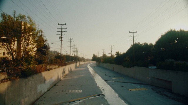 Video Reference: Sky, Plant, Road surface, Overhead power line, Electricity, Asphalt, Land lot, Natural landscape, Thoroughfare, Slope