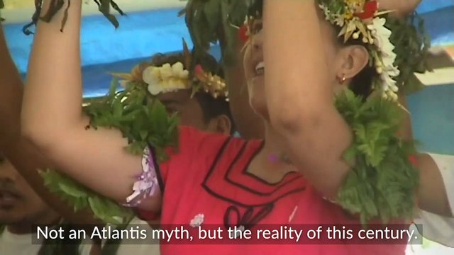 Video Reference: ceremony, festival, dance, flower garland, tradition, people, crowd, indoor, celebration, costume, arms raised, subtitle, cultural event