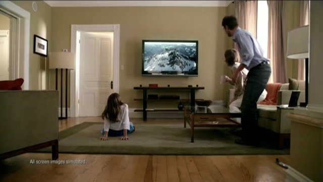 Video Reference: living room, family, television, home interior, people, child, adult, couch, coffee table, rug, window, lamp, indoor, relaxing, watching TV