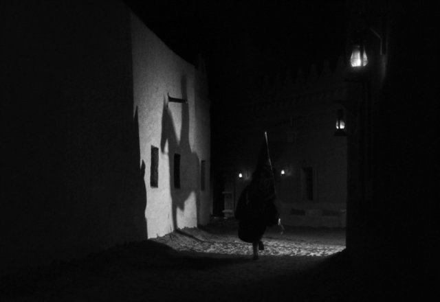 Video Reference: night, alley, street, black and white, silhouette, figure, lantern, dark, shadows, narrow passage, walking, moody, low light, old town, mysterious