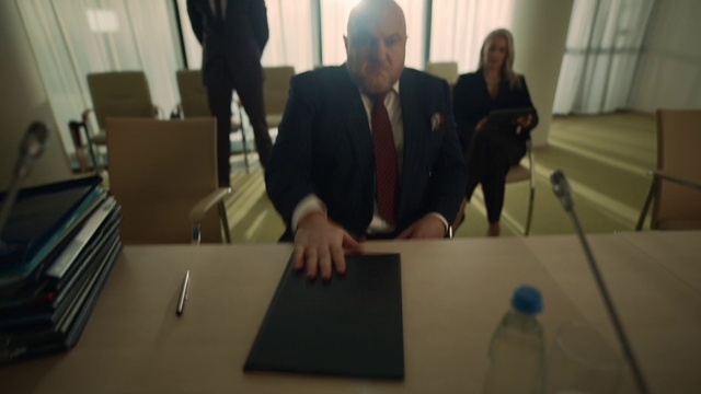 Video Reference: Table, Furniture, Bottle, Coat, Gesture, Suit, Water bottle, Plastic bottle, Chair, Blazer